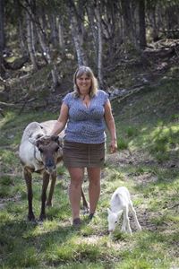 A women with a reindeer and reindeer calf.