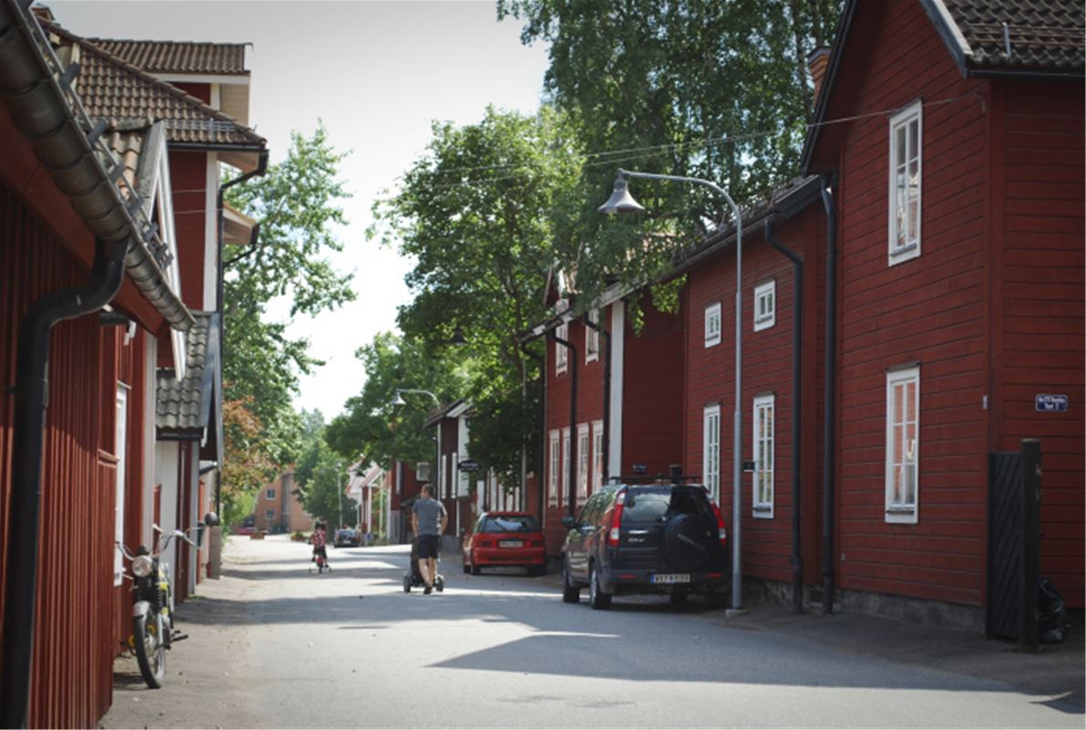 Street with red older wooden buildings on both sides.