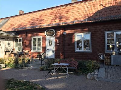 en del av röda huset med dörr in till café.