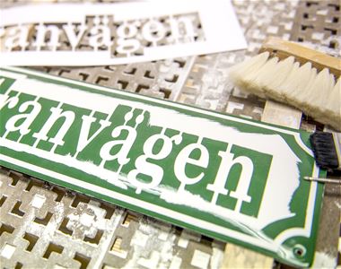 Enamel sign during production, green bottom and white text.
