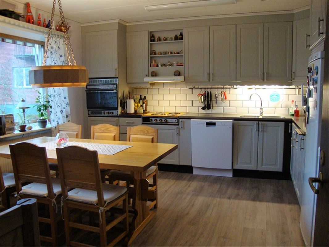 Spacious kitchen with a table and six chairs.