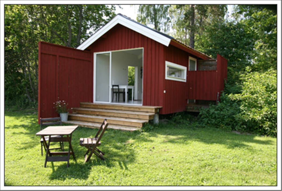 Exterior of red cottage, Ösjöhus, in summer.