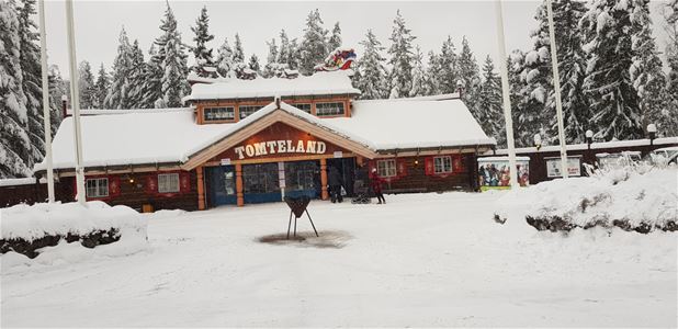 The entrance building of Santaworld with snow on the roof and trees. 