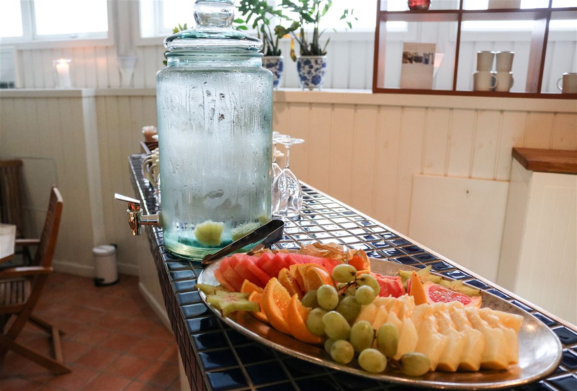 Fruktfat med uppskuren frukt och vattenbehållare med kallt friskt vatten.