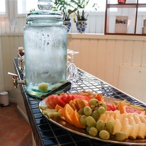 Fruktfat och en karaff med vatten på en bänk.