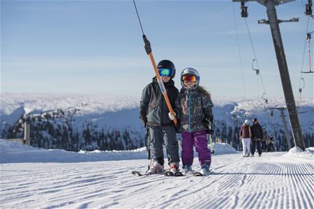 Two children in the lift on their way up to the mountain. 