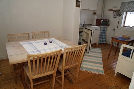 Dining table with four chairs and the pentry in the background. 