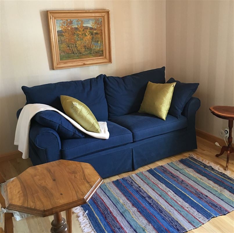 A small blue sofa in a room.