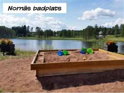 Large sandbox in front of the bathing lake with sandy beach.
