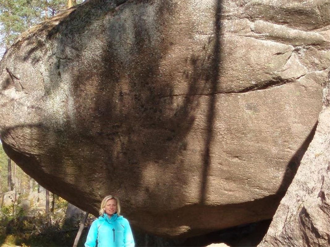 Kvienblocket, large boulder with lady in front.
