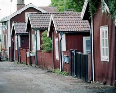 gata med röd äldre träbebyggelse på höger sida i bild.