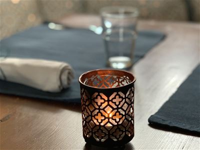 A small candle lantern on a table. 