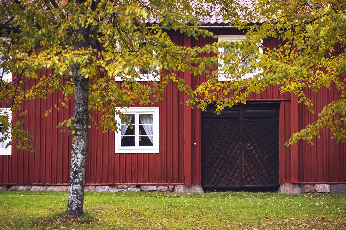 Röd träbyggnad med portlider.