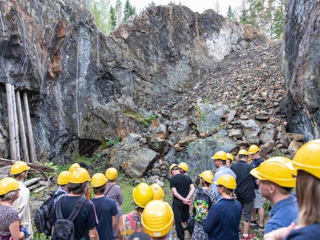 En grupp besökare i gula hjälmar på guidad tur i gruvan.