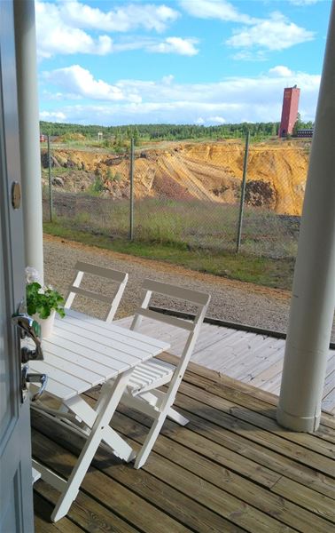 Veranda med bord och stolar ivid kanten till Stora Stöten vid Falu Gruva. 