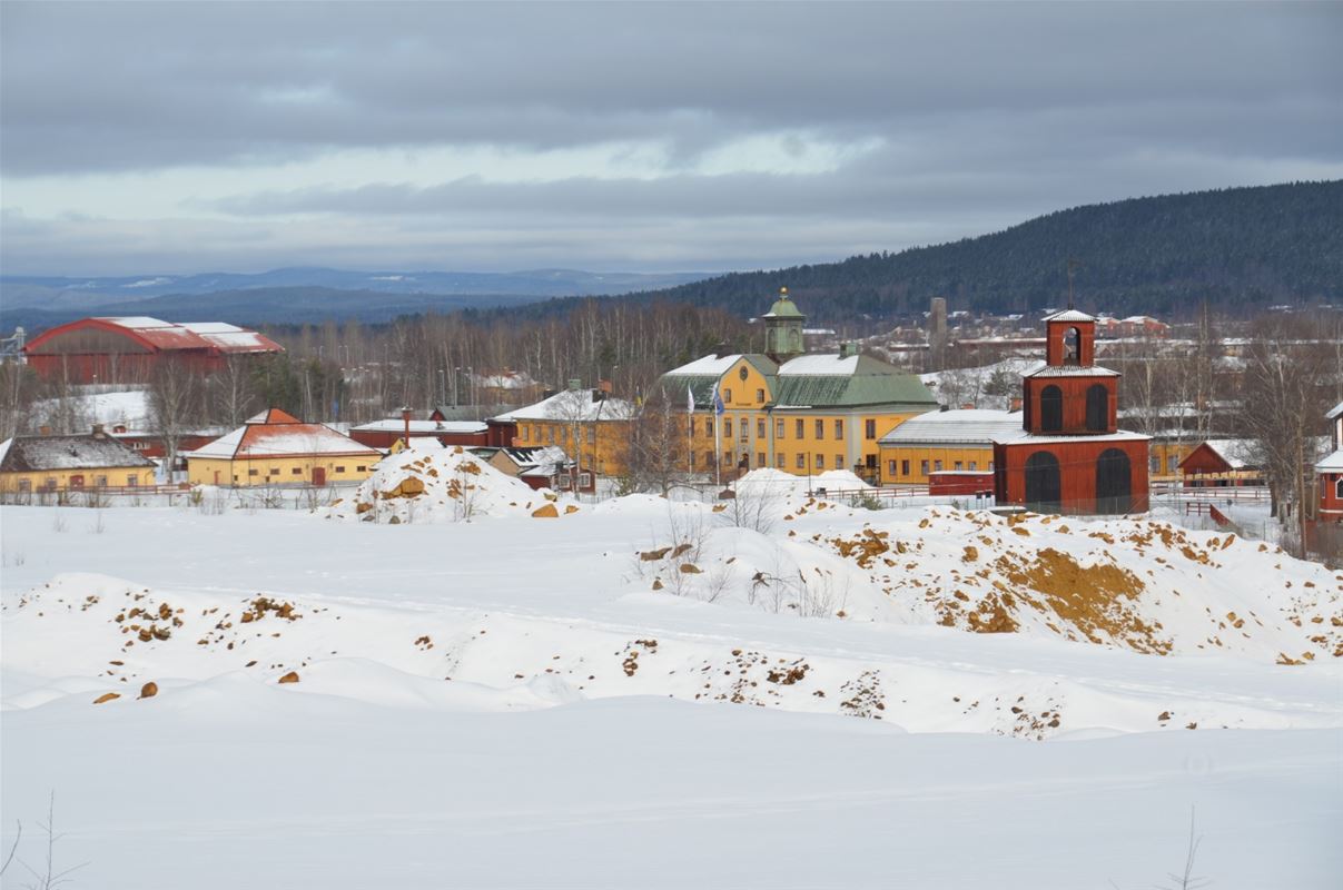 Snötäckt område med Falu Gruvas byggnader i bakgrunden.