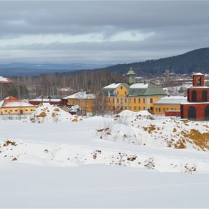 Snötäckt område med Falu Gruvas byggnader i bakgrunden.