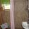 Duschrum med beige vägg och rosa duschdraperi. 