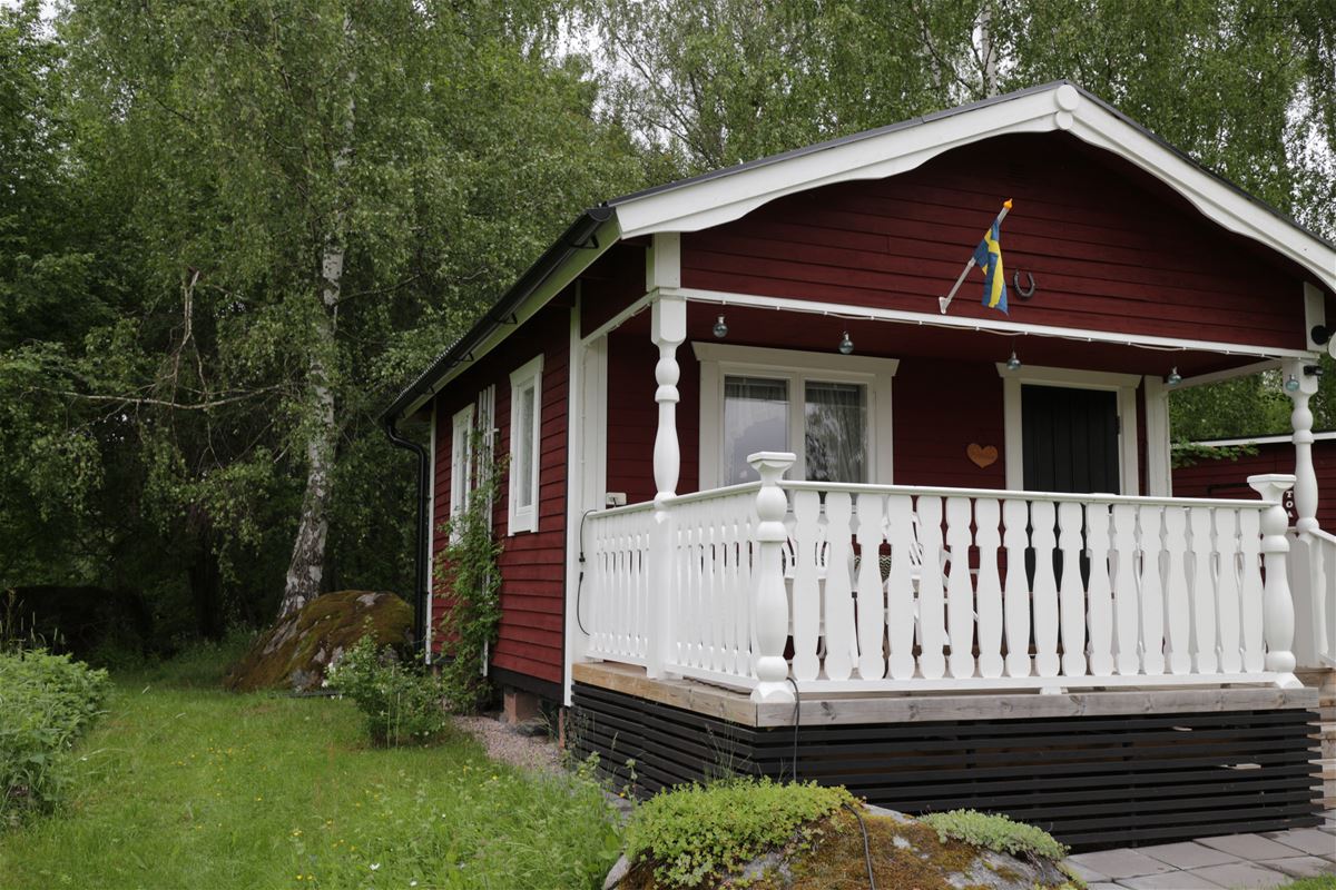 Red painted cottage with a white veranda.