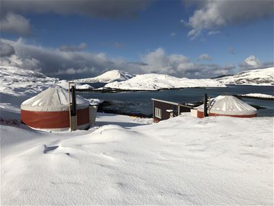To yurter i vinterlandskap ved havet