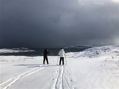 Mann og kvinne går på ski i vinterlandskap