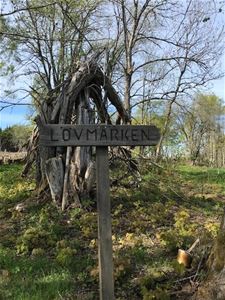 Wooden sign welcoming vistiors to the village of  Lövmarken.