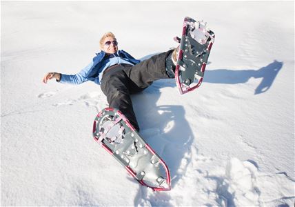 Person fallen down on the snow wearing snowshoes