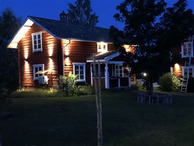 A red painted cottage by night.