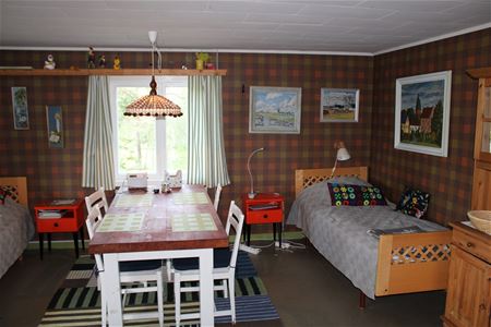 Storstuga med säng och matbord.