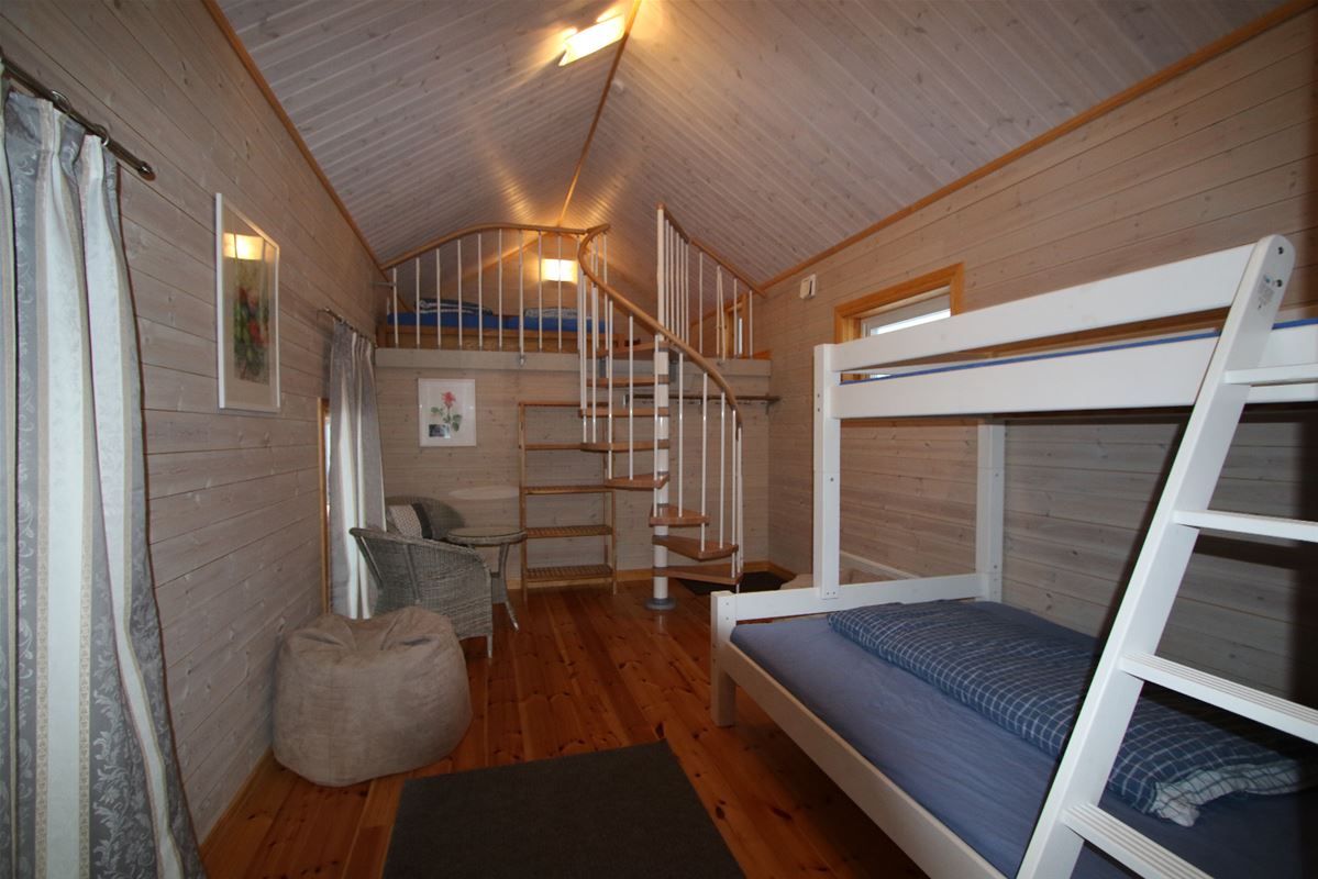 White bunkbed and a spiral stair to the loft. 