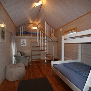 White bunkbed and a spiral stair to the loft. 
