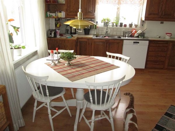 The kitchen with a table and four chairs. 