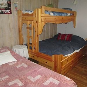 Sovrum med enkelsäng och en våningssäng med bredare underslaf.
