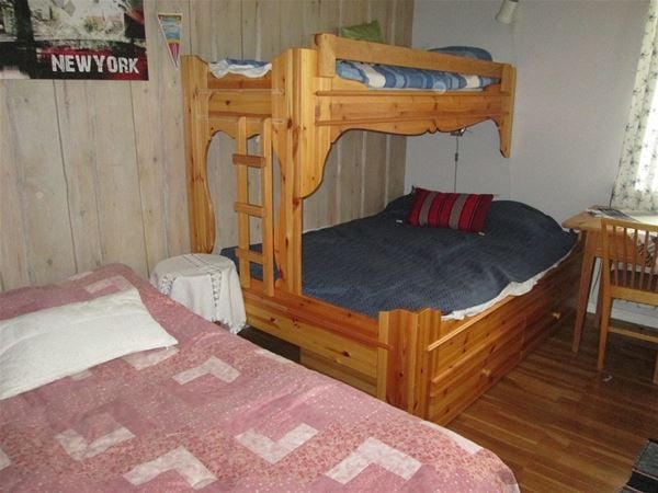 Sovrum med enkelsäng och en våningssäng med bredare underslaf. 