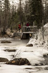 Hikers by frozen river.