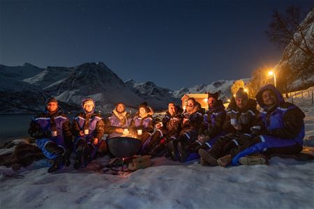 group of people waiting around a bonfire