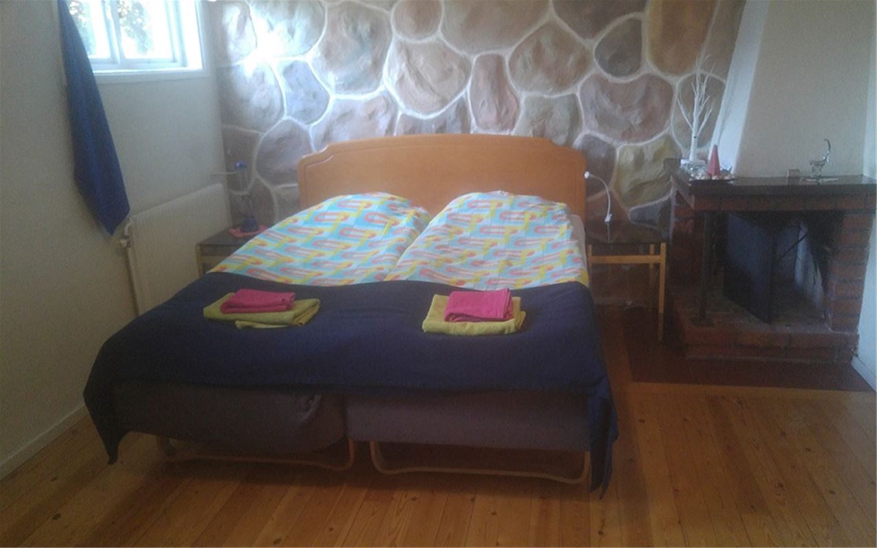 Double bed in a wooden frame in the basement.