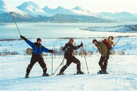 Three persons having fun on snowshoes