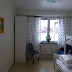 Rum med fönster och våningssäng med bred underslaf.