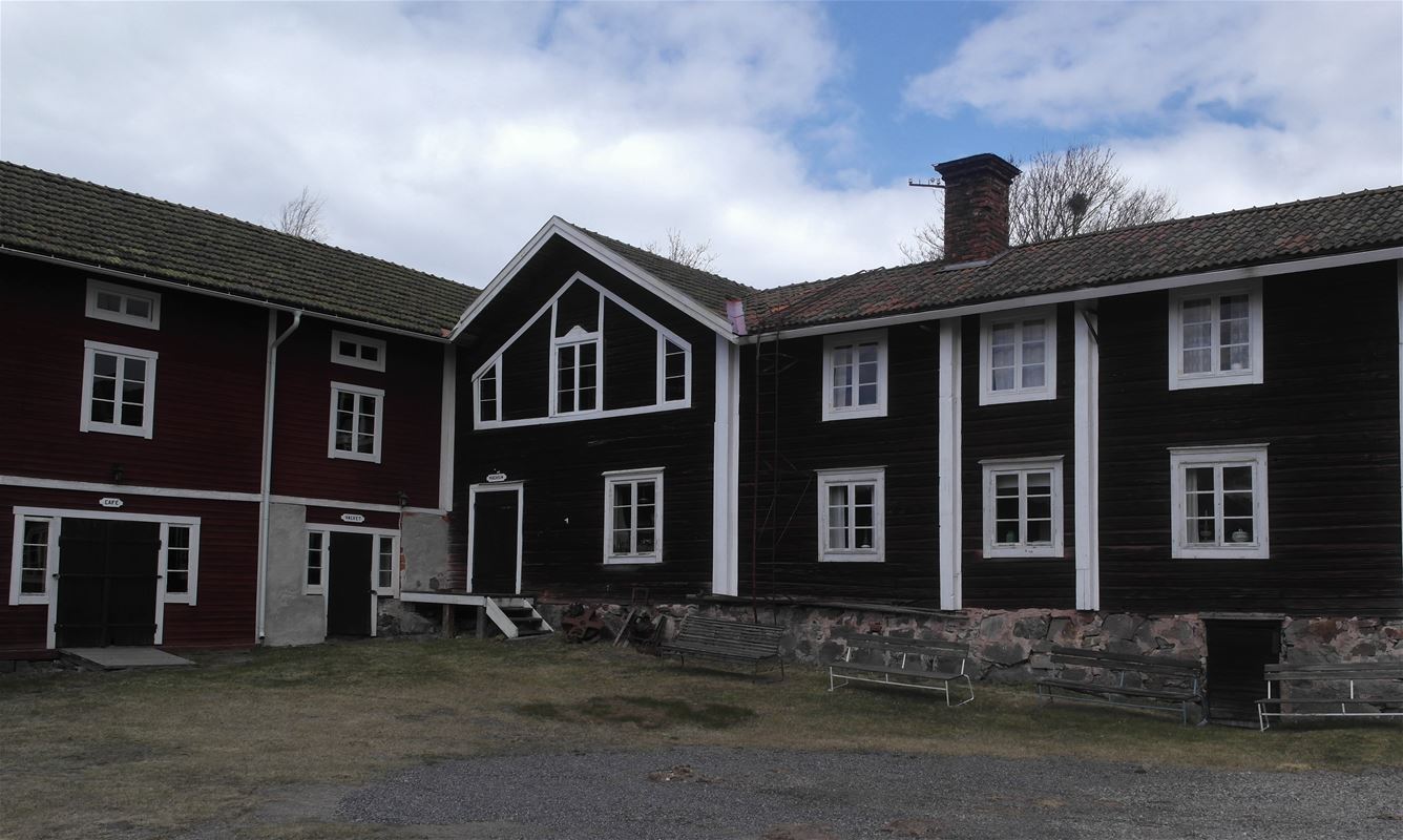Stort rött hus med vita knutar och grunden i sten. 