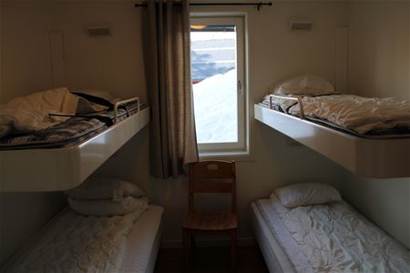 Bedroom with two beds and two beds on the wall.