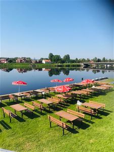 The outdoor seating on the lawn next to the river.