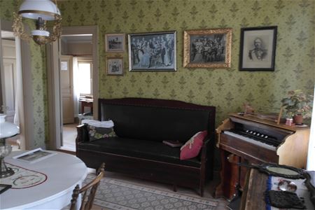 Ett piano och en äldre soffa i ett rum. 