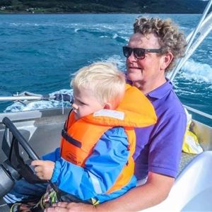  © Dyrøy Holiday, Mann og barn kjører båt