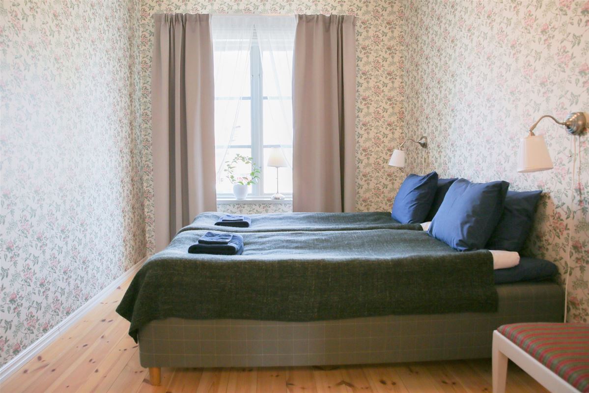 A twinbed with a window in the end of the room with a view of Falu Gruva.