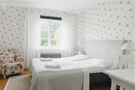 Hotellrum, dubbelsäng, fåtölj, skrivbord.