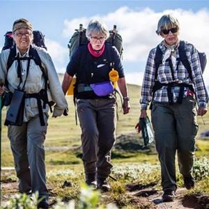 Three women hiking over the mountains.