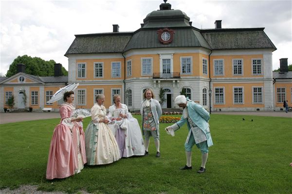 Människor i 1700-tals kläder utanför Österbybruks herrgård 