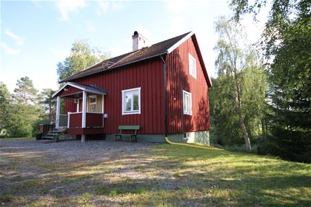 Exterior of a red painted cottage.