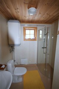 Badrum med glasdörrar till duschen och en toalett.